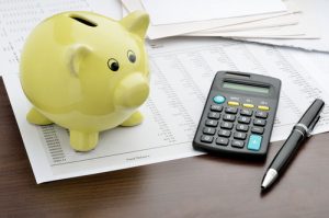 piggy bank with calculator and financial paperwork budgeting