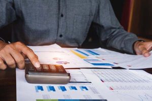 Man with calculator and spreadsheets 