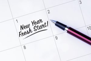 Close up of a calendar with the words “New Year Fresh Start!” written on the first date.