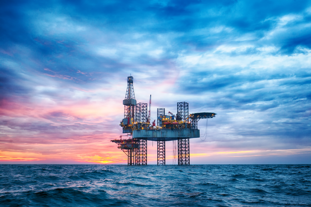 high definition photo of an offshore jack-up rig in the middle of the sea at sunset time